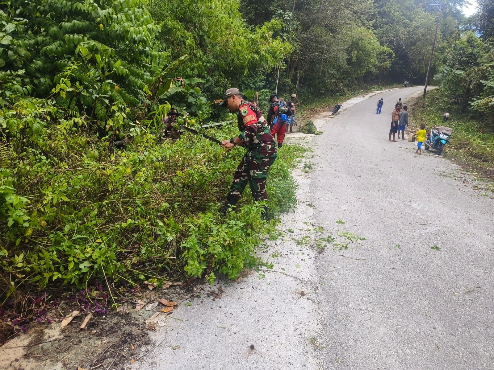 Semangat Sambut HUT RI Ke-81 Babinsa Fajrin dan Warga Kayauni Bersihkan Jalan Menuju Ibu Kota Distrik
